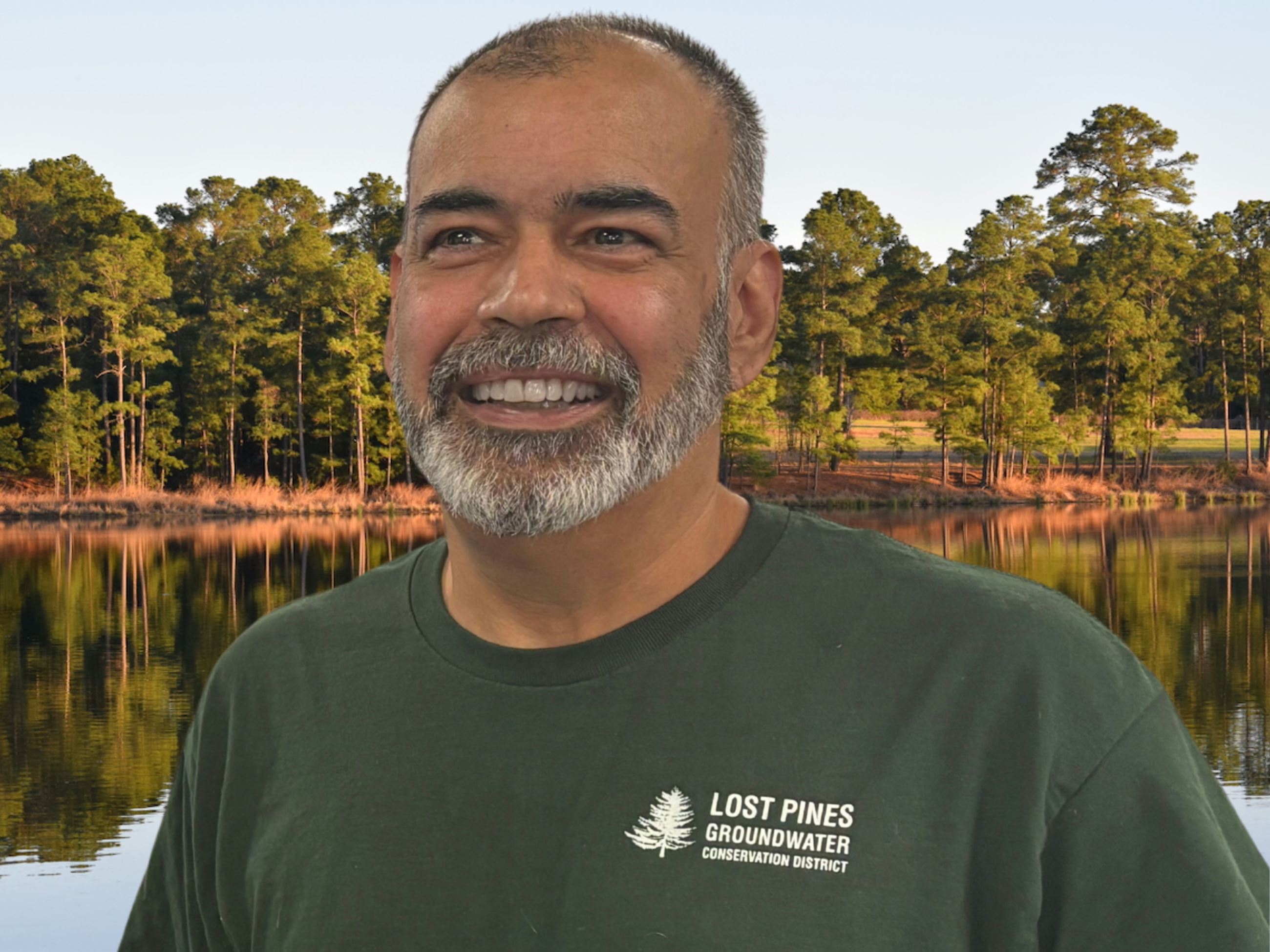 Image of man smiling with trees behind him
